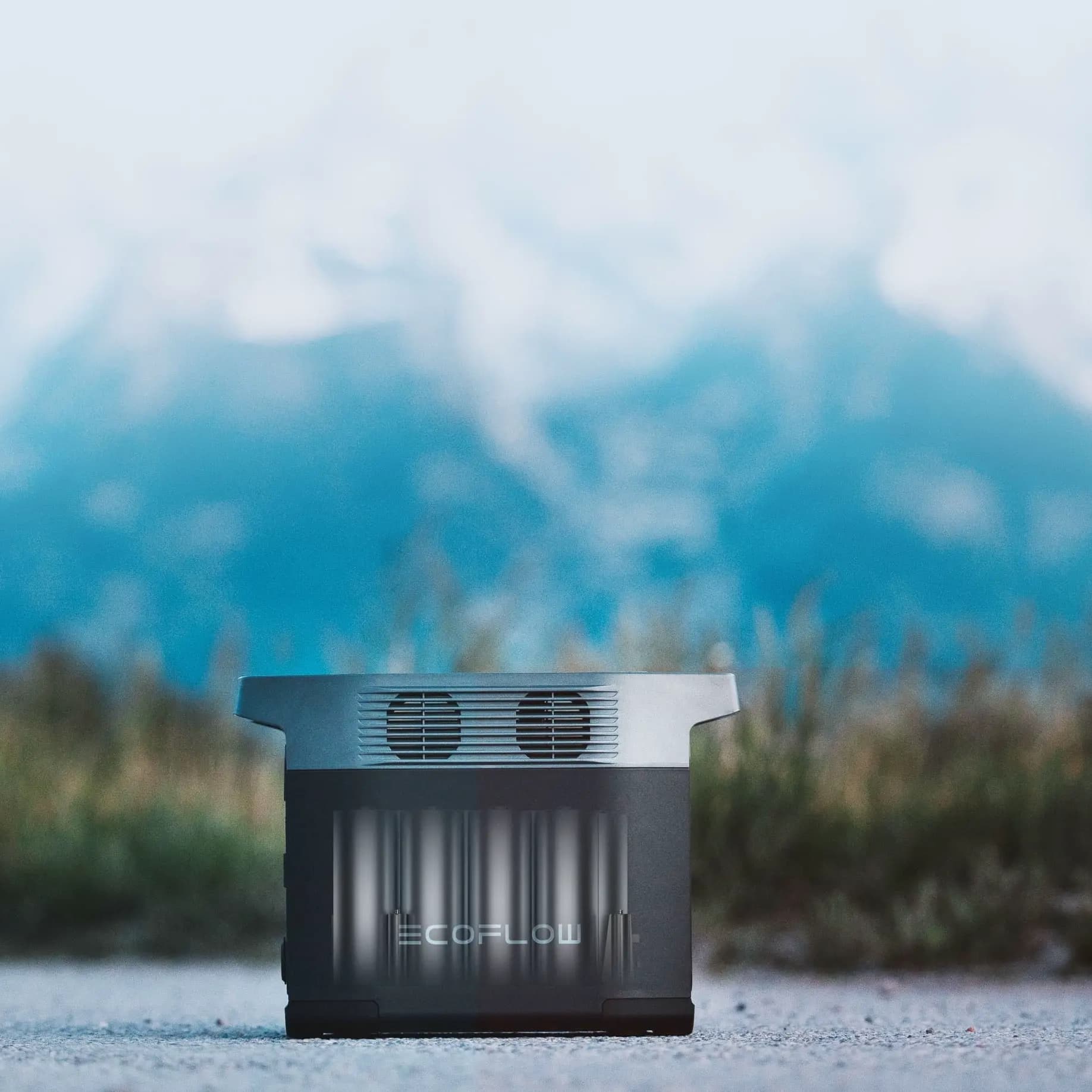 EcoFlow Delta 2 portable power station on a gravel path in front of mountains